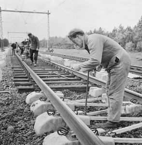 859275 Afbeelding van wegwerkers van de N.S. tijdens het leggen van spoor met zig-zag dwarsliggers.